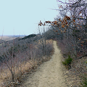 Trail along the ridge with flat horizon in the distance.